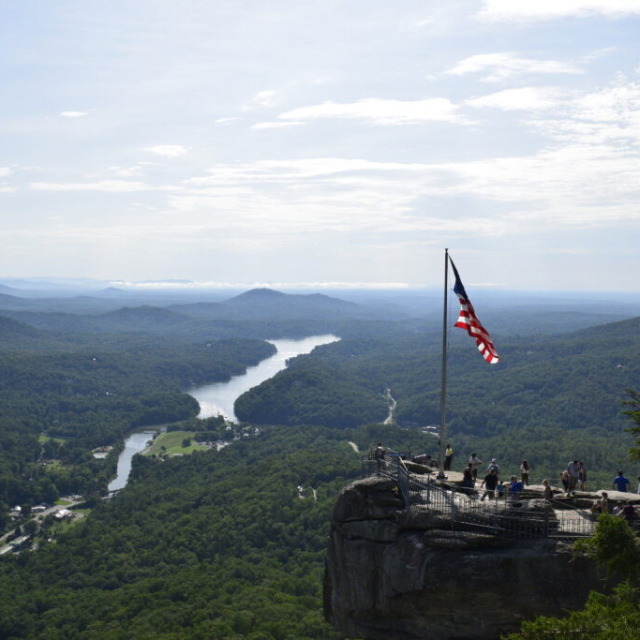 Chimney Rock with a flag flying, overlooking the surrounding mountains.