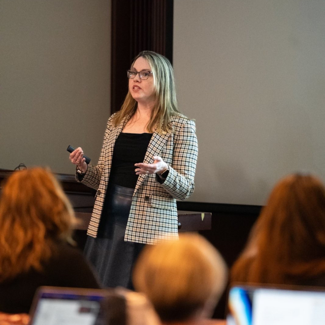 Dr. Hailger giving a lecture to an audience in a conference setting.